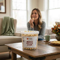 Doodle's Sugarbush, LLC - 100% Pure Michigan Maple Syrup kettle corn in a clear tub on a wooden table with a woman